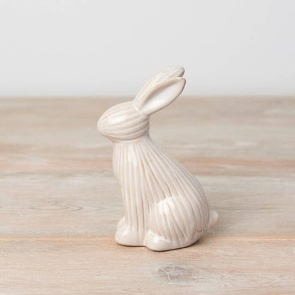 Sitting ceramic bunny with a ribbed reactive glaze finish in white/cream. A charming Easter or spring décor item.