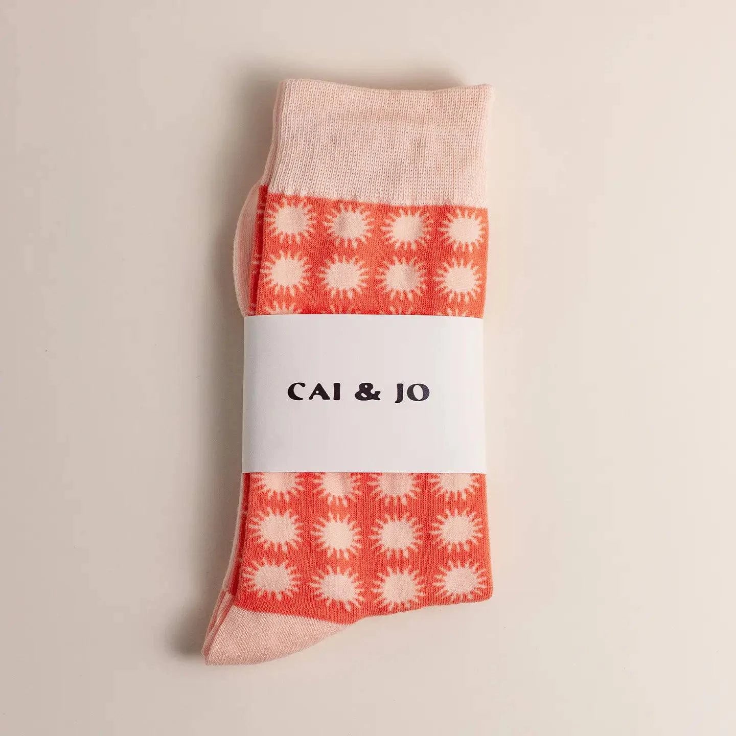 Orange socks featuring an all-over sunshine design. Made from 75% cotton for comfort, one size fits most. In packaging