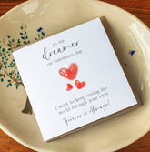 Handmade Valentine’s Day card featuring three red hearts and the text: "To my dreamer on Valentine’s Day, I want to see the world through your eyes forever and always."