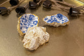 Set of three handmade oyster shell trinket dishes with blue and white floral designs, featuring a decoupage technique and hand-painted gold edges, ideal for home decor or jewellery storage.