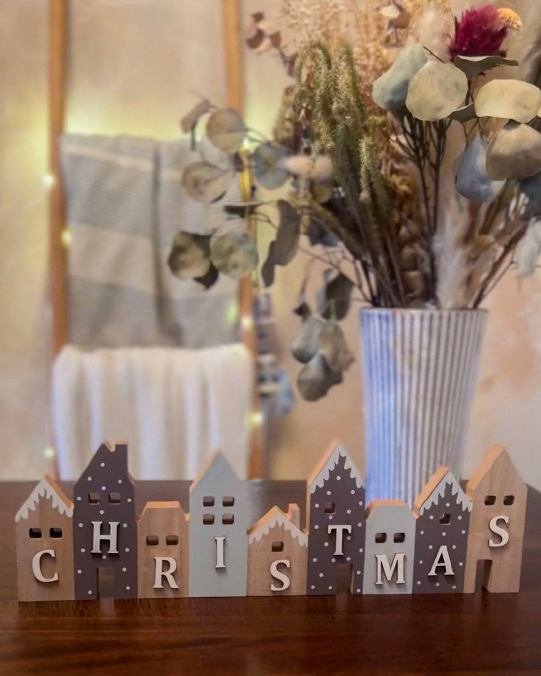 Set of wooden Christmas houses adorned with blue and grey snow-effect designs. A charming festive décor piece.