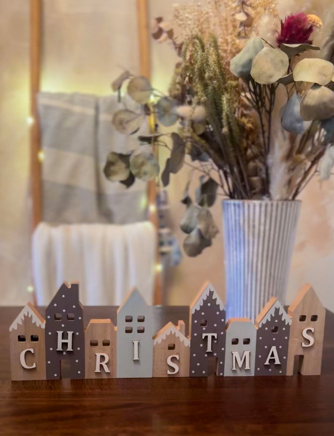 Set of wooden Christmas houses adorned with blue and grey snow-effect designs. A charming festive décor piece.